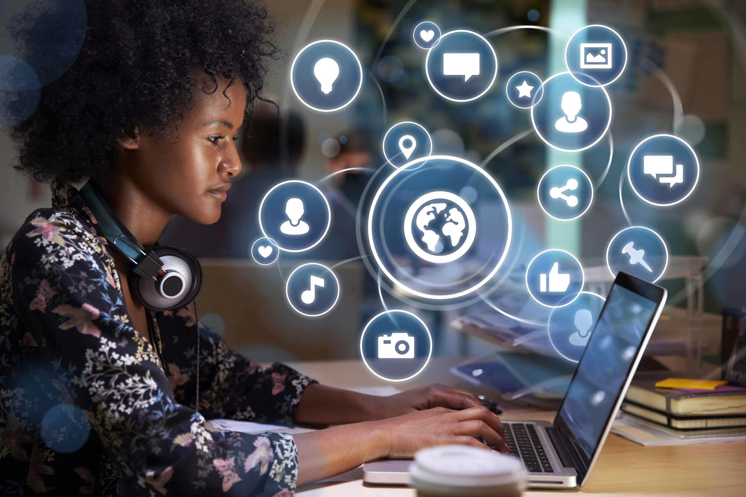 Conceptual Image Of Young Woman Using Social Media On Laptop With Holographic Icons Projected From Screen